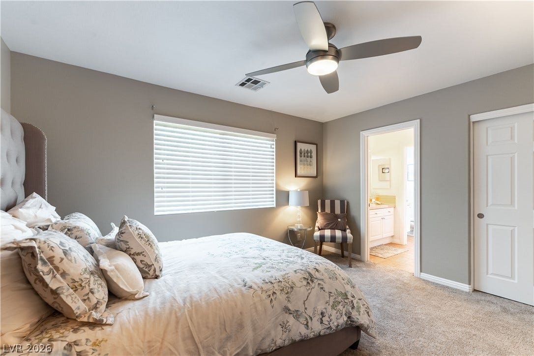 2676 Botticelli Drive, Henderson, NV 89052 A well-lit bedroom with a ceiling fan, and light with large closet and bathroom access.