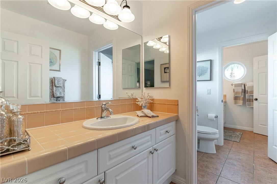2676 Botticelli Drive, Henderson, NV 89052 A pristine bathroom off the bedroom features a single vanity with lots of counter space and bright overhead lighting.