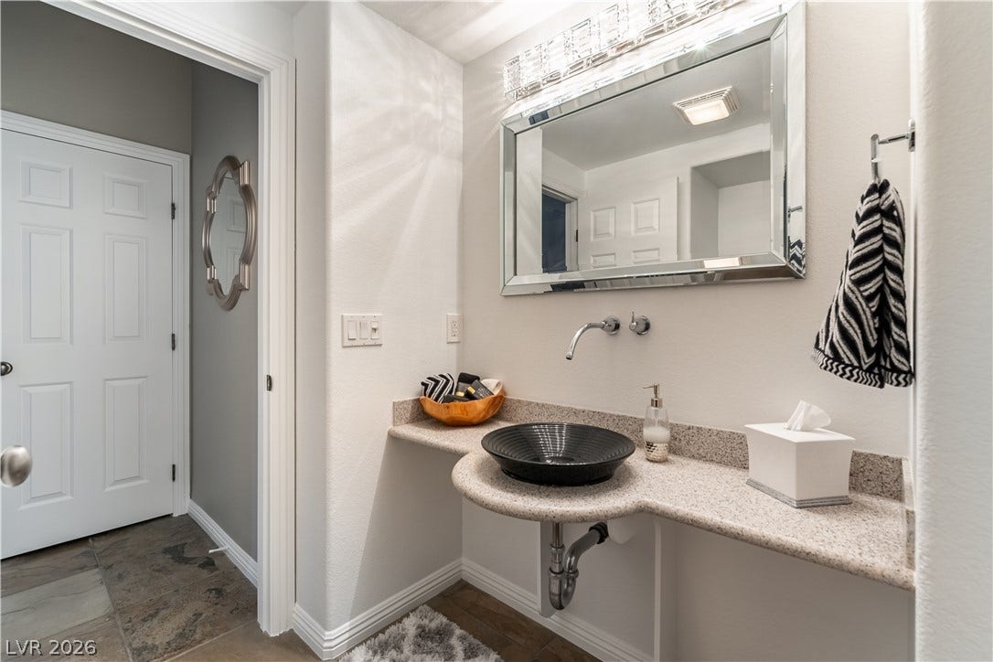 2676 Botticelli Drive, Henderson, NV 89052 downstairs 1/2 bath with vessel sink vanity provides a modern touch in this powder room.