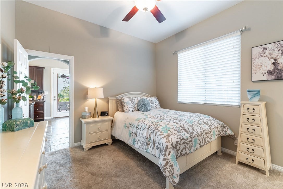 2676 Botticelli Drive, Henderson, NV 89052 Downstairs bedroom with full bathroom and features ceiling fan with light and a window offering natural illumination.