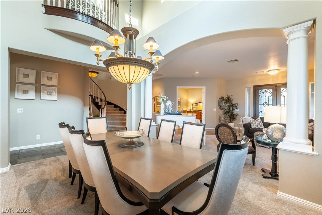 2676 Botticelli Drive, Henderson, NV 89052 A stylish chandelier illuminates the formal dining area, complementing the grand staircase and arched entryways.