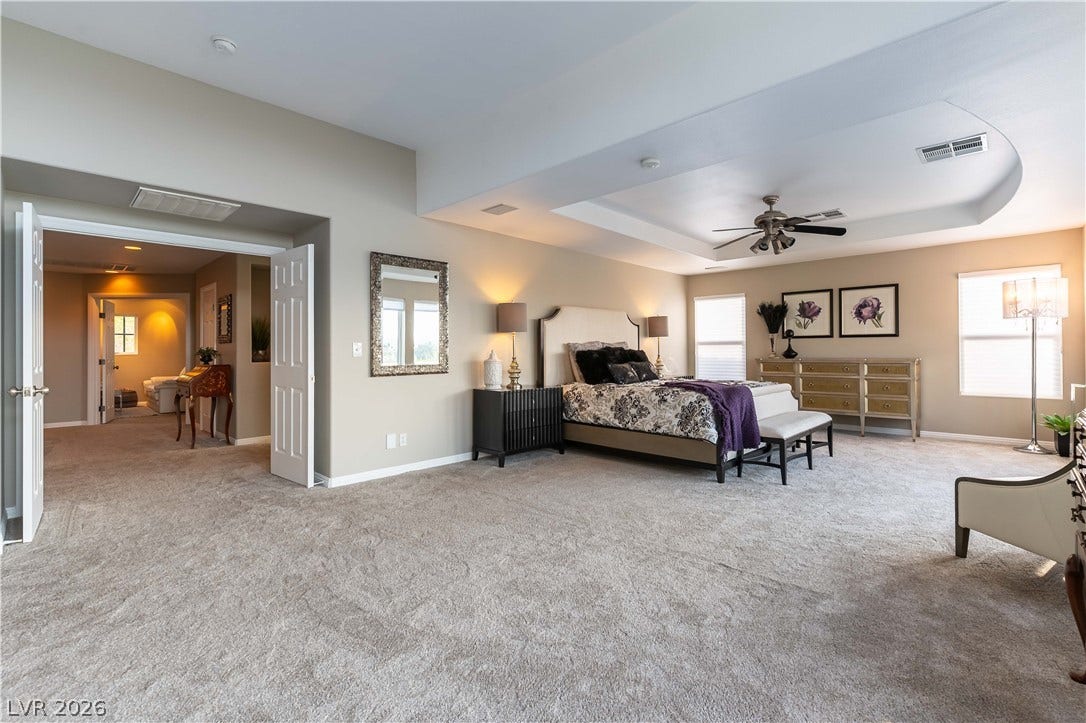 2676 Botticelli Drive, Henderson, NV 89052 A spacious primary bedroom features a coffered ceiling, recessed lighting, ceiling fan and a neutral color palette, creating a serene personal retreat.