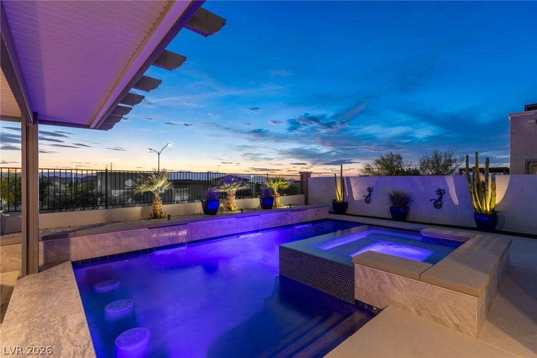 743 Glowing Horizon Street, Henderson, NV 89052 A private outdoor oasis, featuring a glistening pool and spa under a captivating evening sky.