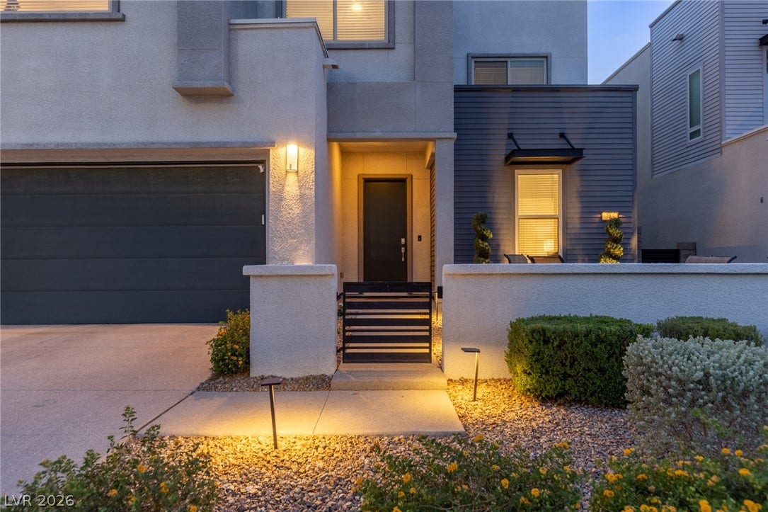 743 Glowing Horizon Street, Henderson, NV 89052 A striking modern facade features a contrasting gray garage and inviting walkway with pathway lighting.