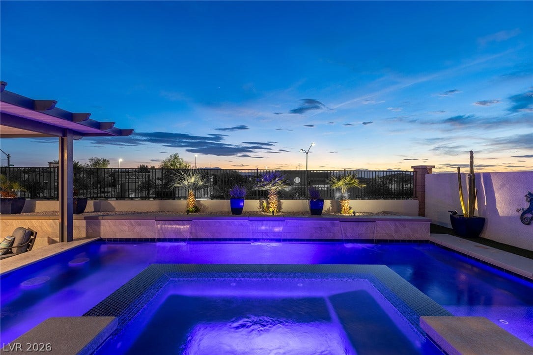 743 Glowing Horizon Street, Henderson, NV 89052 An inviting backyard oasis offers a luxurious pool with an integrated spa, all under a tranquil evening sky.