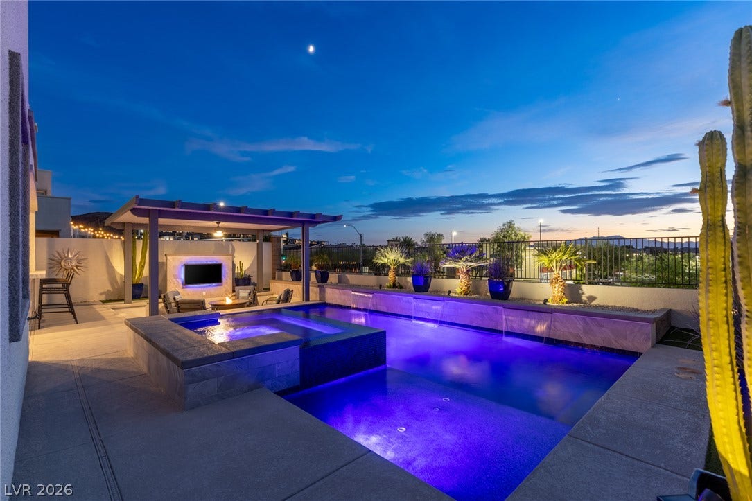 743 Glowing Horizon Street, Henderson, NV 89052 An illuminated pool and spa anchor this captivating outdoor entertaining area, complete with a cozy fire pit.