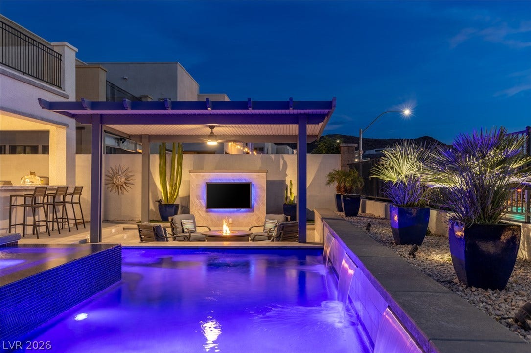 743 Glowing Horizon Street, Henderson, NV 89052 An inviting outdoor living area awaits, complete with a pool, bar, and cozy fire pit for evening relaxation.