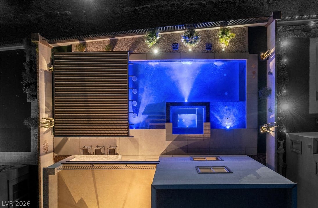 743 Glowing Horizon Street, Henderson, NV 89052 An aerial perspective reveals a private pool with glowing blue lights and an adjacent spa, set in a modern outdoor living area.