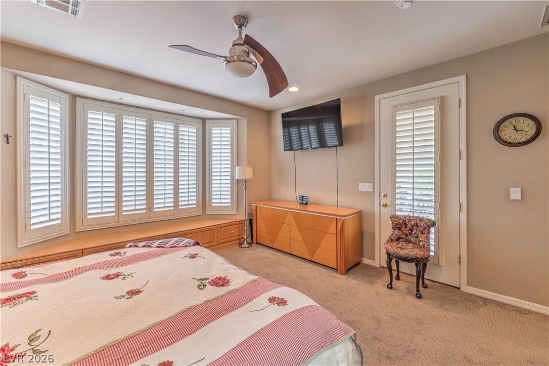 10298 Profeta Court, Las Vegas, NV 89135 This naturally illuminated primary bedroom features a wide bay window with integrated storage, and a ceiling fan for optimal comfort.