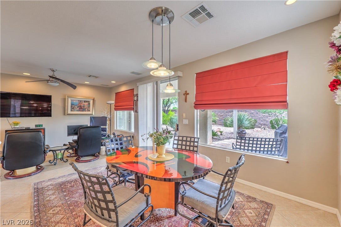 10298 Profeta Court, Las Vegas, NV 89135 A vibrant dining area features an artistic oval table with a modern pendant light fixture and desert views.