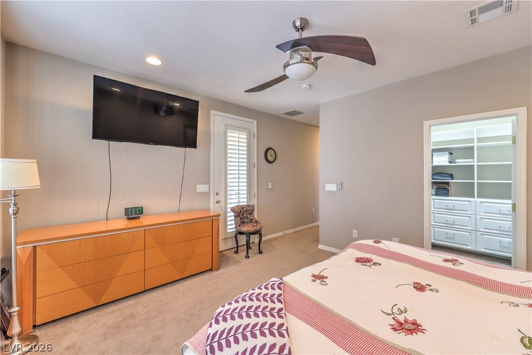 10298 Profeta Court, Las Vegas, NV 89135 A well-lit bedroom features plush carpeting, a modern ceiling fan, and convenient access to a walk-in closet.