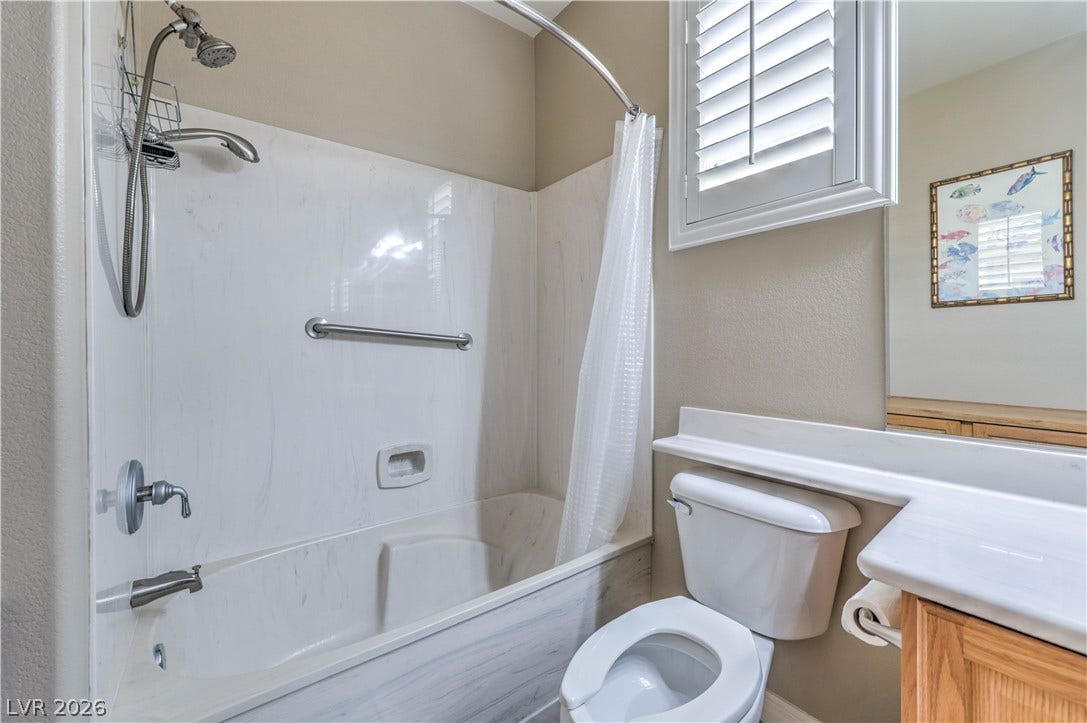 10298 Profeta Court, Las Vegas, NV 89135 A well-appointed bathroom features a combined shower and tub, along with a window fitted with crisp plantation shutters.