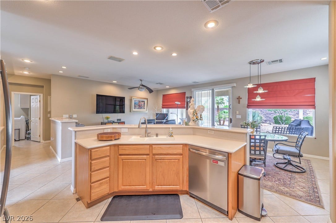 10298 Profeta Court, Las Vegas, NV 89135 An open-concept living space features a functional kitchen island and a dining area with views of the outdoor landscape.