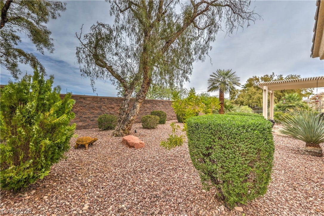 10298 Profeta Court, Las Vegas, NV 89135 Mature trees and lush desert landscaping create a private backyard oasis with a covered patio.