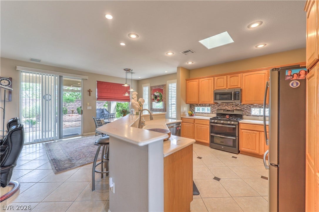 10298 Profeta Court, Las Vegas, NV 89135 A chef's dream kitchen offers a large island with a breakfast bar, ample cabinetry, and direct patio access.