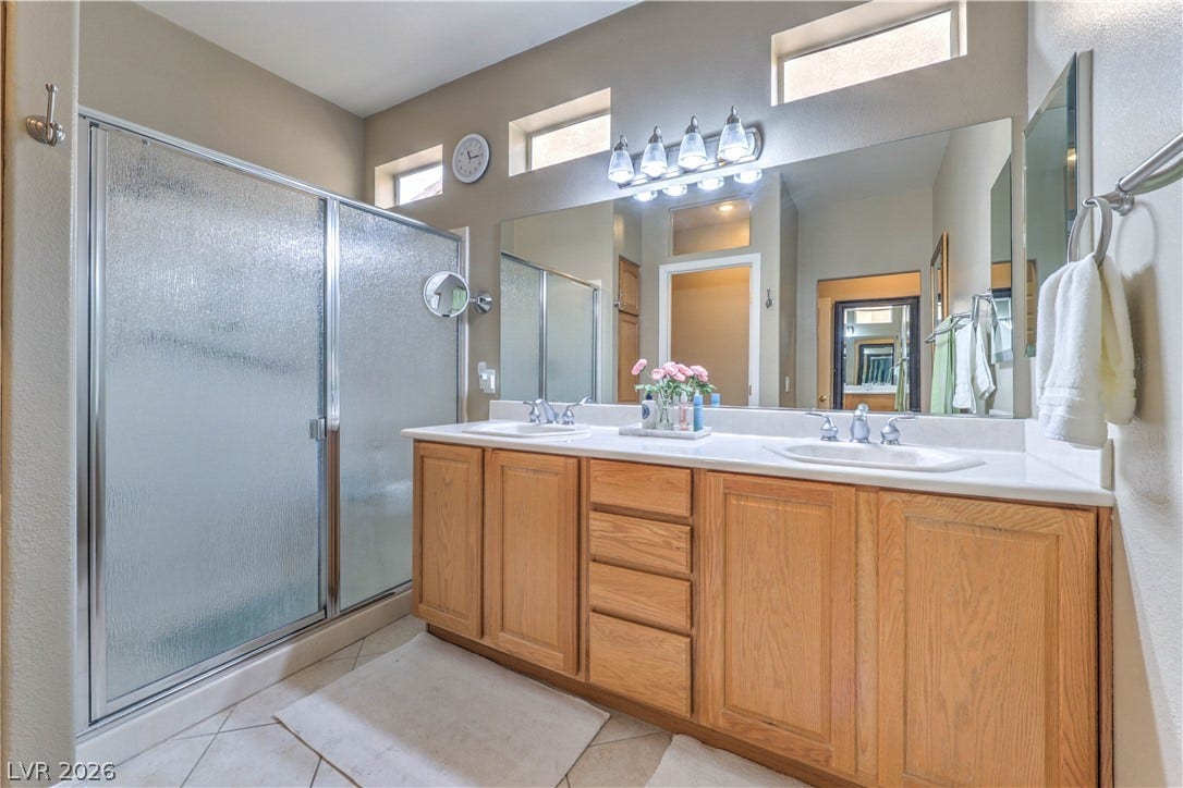 10298 Profeta Court, Las Vegas, NV 89135 Dual vanity with ample storage and a clear glass shower stall create a functional bathroom.