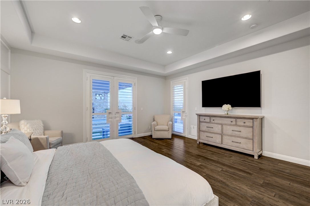 274 Evante Street, Las Vegas, NV 89138 Recessed lighting and a ceiling fan illuminate this spacious bedroom with dark hardwood flooring and access to the outdoors.