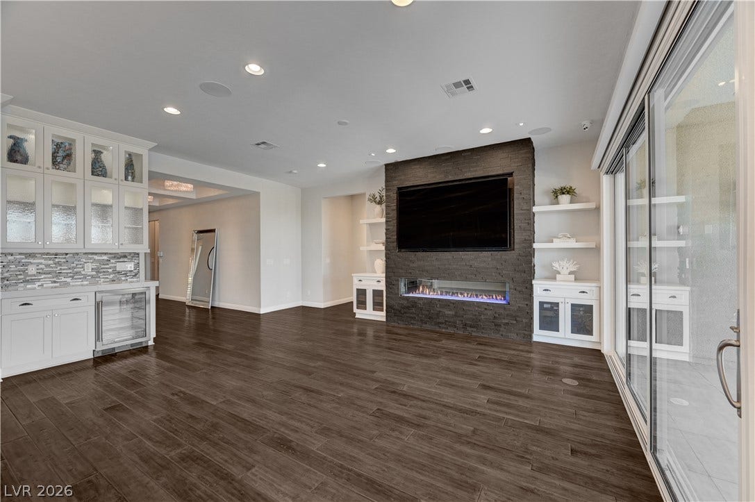 274 Evante Street, Las Vegas, NV 89138 Rich wood floors and a contemporary stone fireplace wall anchor this versatile living area.