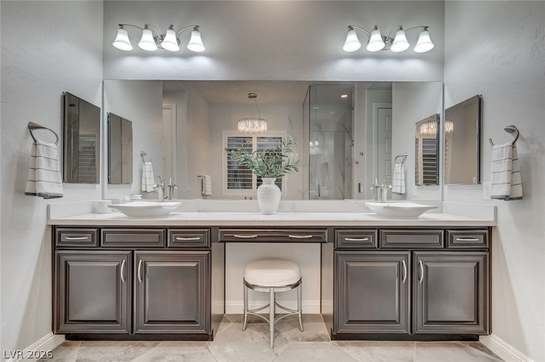 274 Evante Street, Las Vegas, NV 89138 Double vanities with sleek vessel sinks and ample counter space create a functional and elegant primary bathroom.