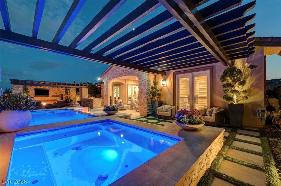274 Evante Street, Las Vegas, NV 89138 An illuminated pool and spa anchor a luxurious outdoor living space, perfect for evening relaxation.