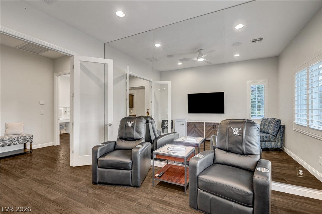 274 Evante Street, Las Vegas, NV 89138 Entertaining awaits in this media room, featuring dark wood flooring and a mirrored accent wall.