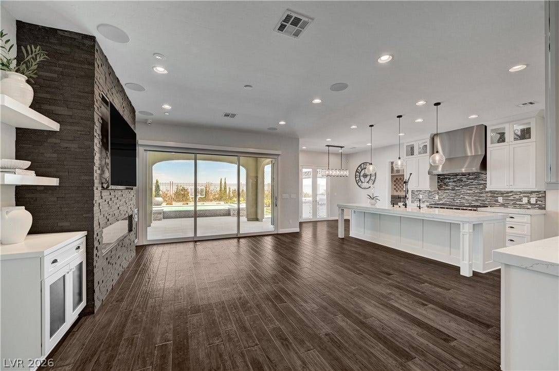 274 Evante Street, Las Vegas, NV 89138 Rich wood floors seamlessly connect a stacked-stone fireplace accent wall to the gourmet kitchen.