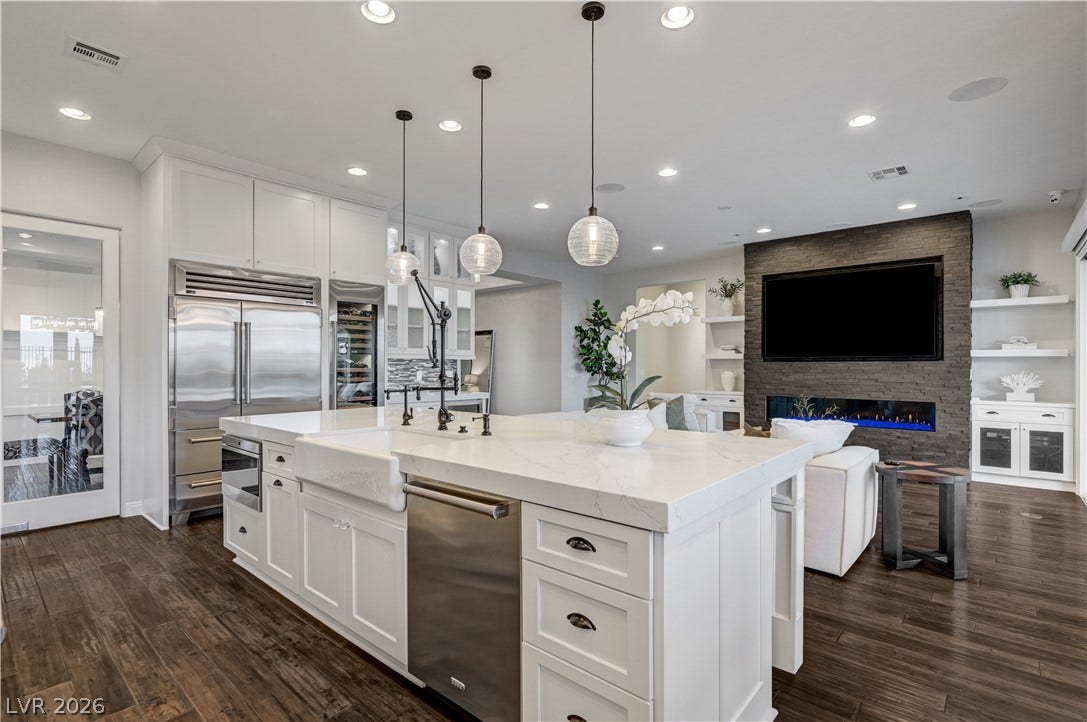 274 Evante Street, Las Vegas, NV 89138 A well-lit kitchen with a spacious island flows seamlessly into a living area with a contemporary fireplace.