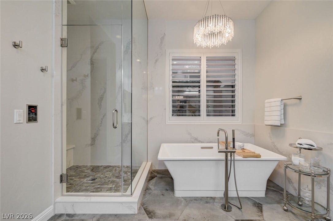 274 Evante Street, Las Vegas, NV 89138 A spacious, naturally illuminated bathroom features a freestanding soaking tub and a walk-in shower with elegant tile work.