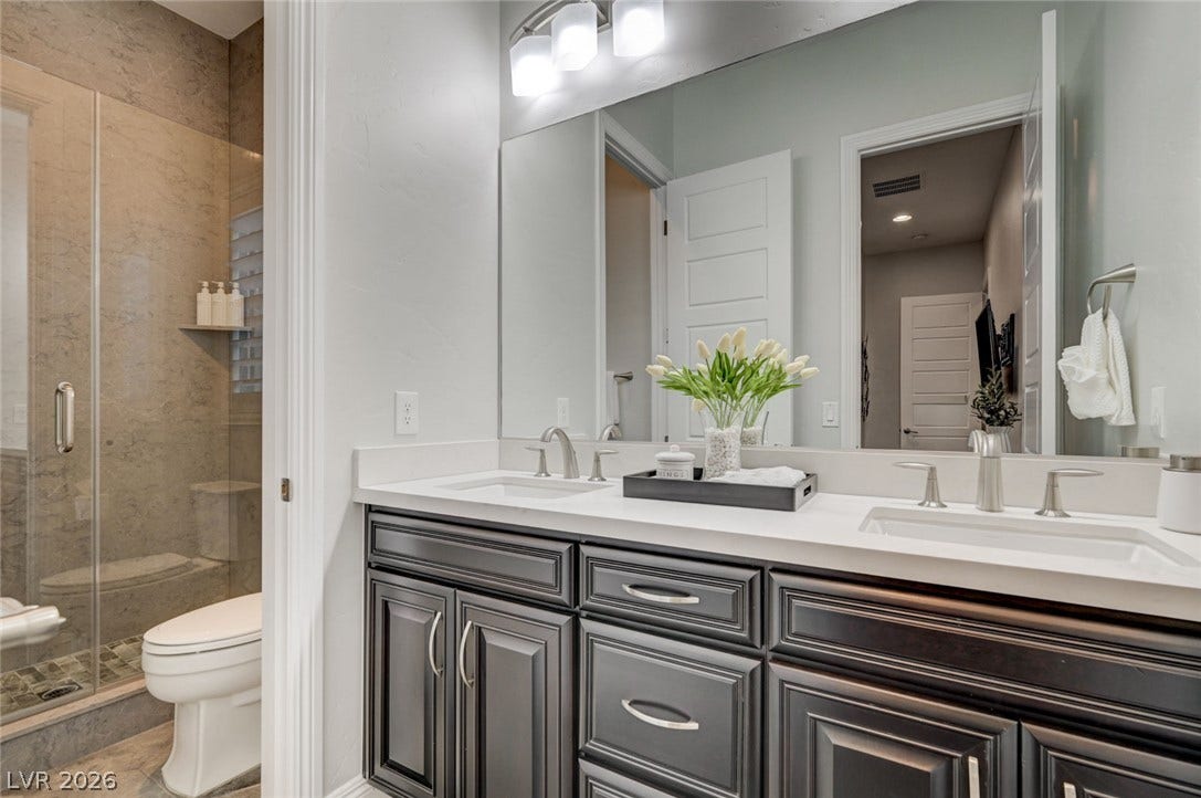 274 Evante Street, Las Vegas, NV 89138 A well-appointed bathroom features a spacious dual-sink vanity and an elegant glass-enclosed shower.