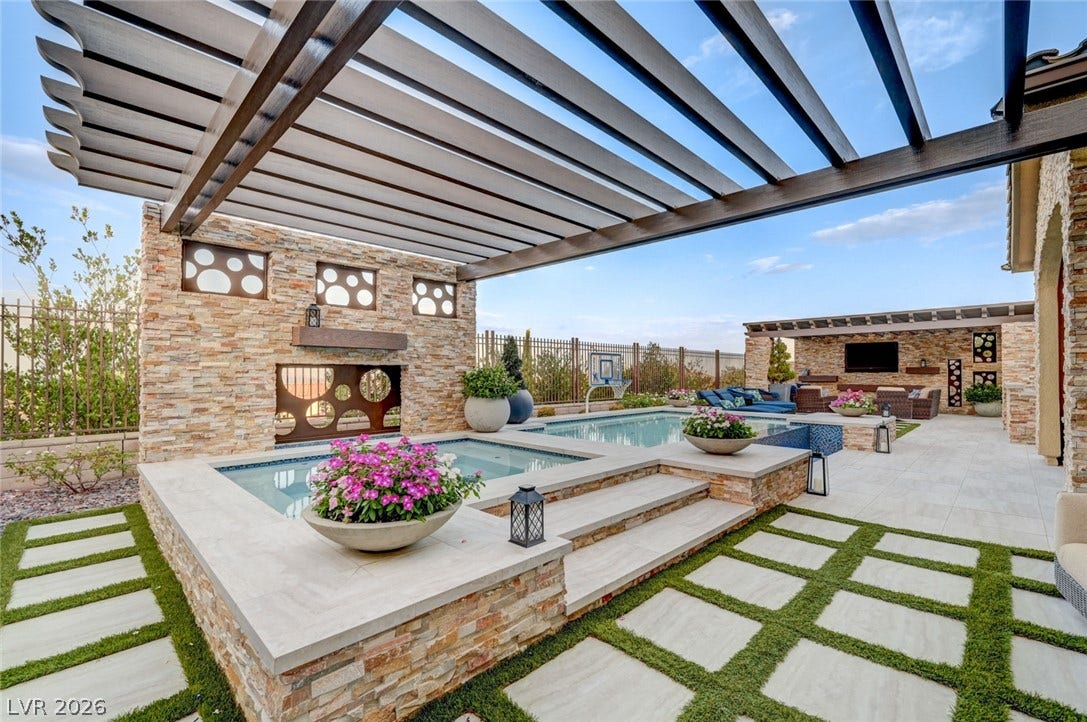 274 Evante Street, Las Vegas, NV 89138 An inviting backyard oasis offers a sparkling pool and spa, alongside an entertainment area, perfect for relaxation.
