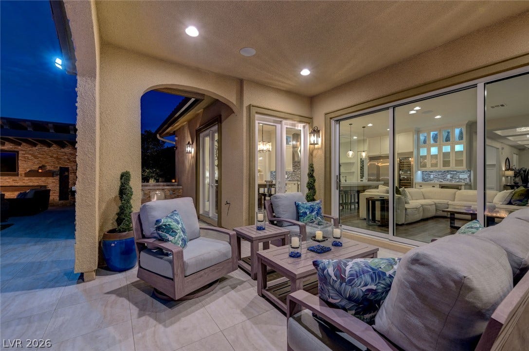 274 Evante Street, Las Vegas, NV 89138 An inviting outdoor patio, perfect for evening gatherings, features a covered sitting area with stylish furniture and warm lighting.