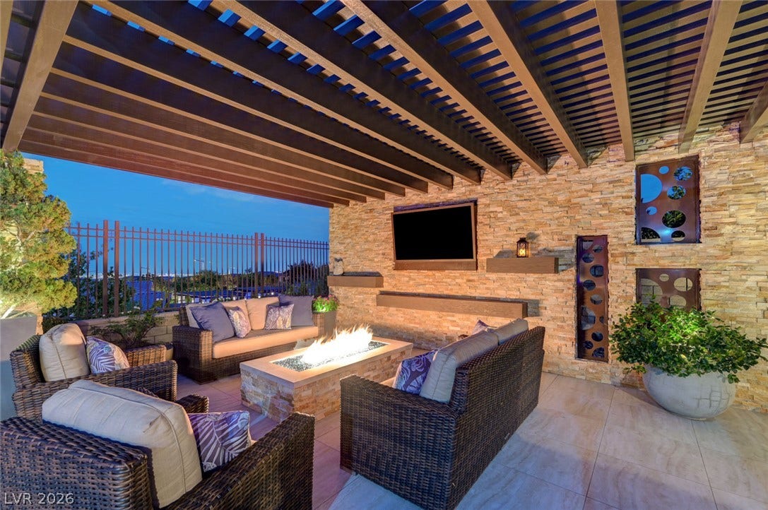 274 Evante Street, Las Vegas, NV 89138 An inviting outdoor living space features a cozy fire pit, perfect for evening gatherings under the pergola.