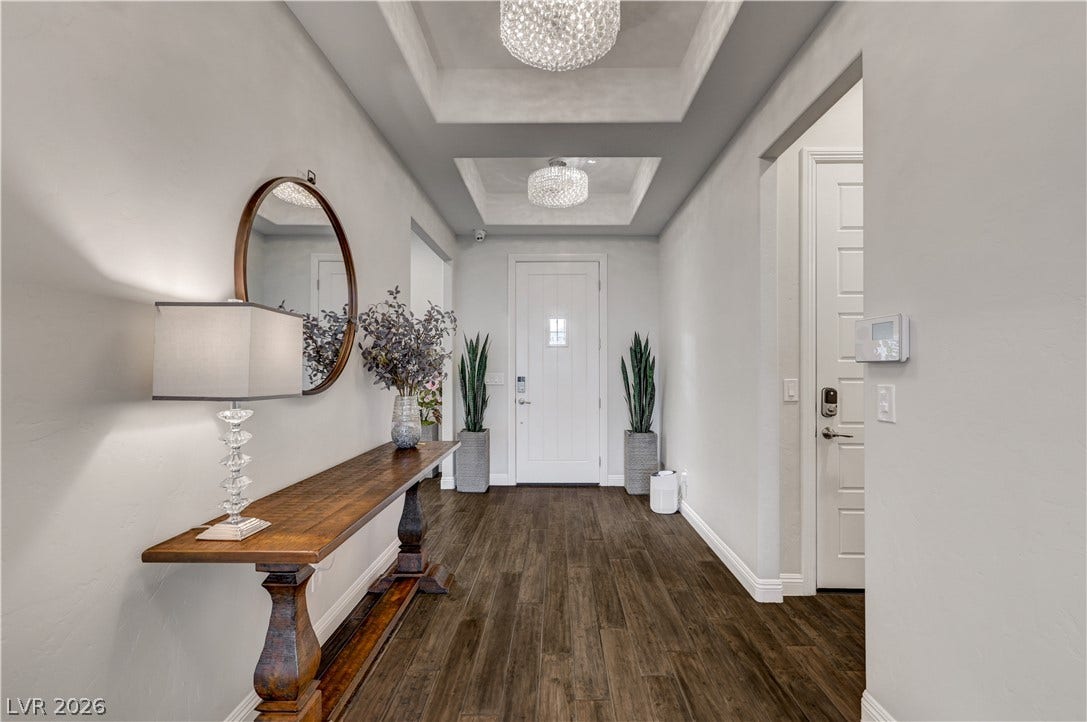 274 Evante Street, Las Vegas, NV 89138 Rich wood flooring grounds this elegant entry, welcoming guests beneath layered tray ceilings with sparkling chandeliers.