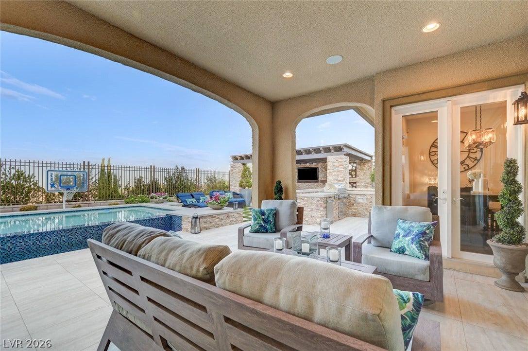 274 Evante Street, Las Vegas, NV 89138 An inviting covered patio features ample seating, a sparkling pool, and an outdoor kitchen for alfresco entertaining.