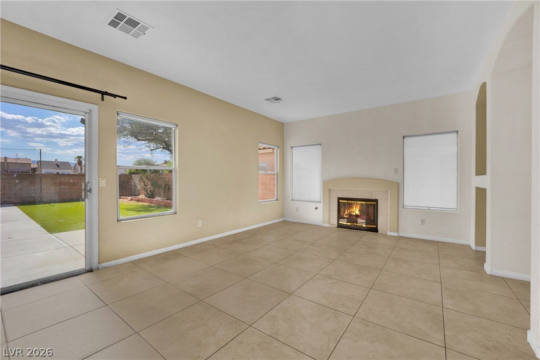 5823 Golden Wing Street, Las Vegas, NV 89113 A well-lit living area offers durable tile flooring and a cozy fireplace, perfect for relaxation.