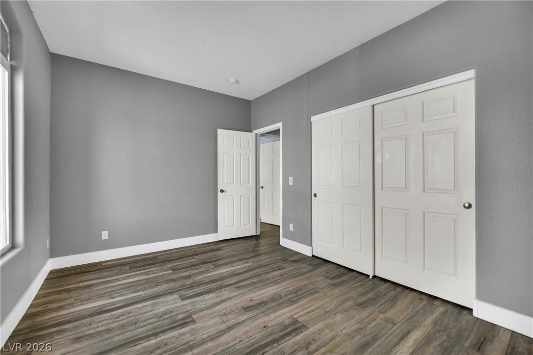 5823 Golden Wing Street, Las Vegas, NV 89113 Well-lit room with wood flooring and convenient closet access, offering a versatile living space.