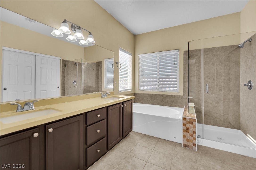5823 Golden Wing Street, Las Vegas, NV 89113 Dual vanities and a deep soaking tub create a luxurious primary bathroom retreat.