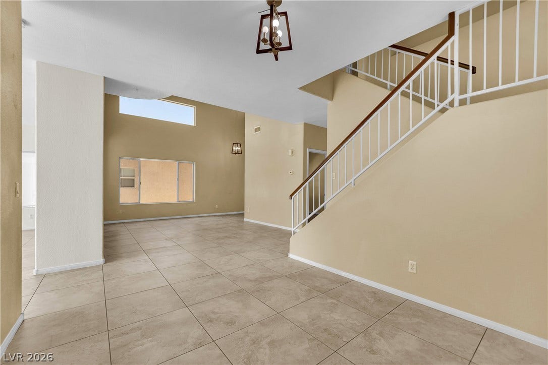 5823 Golden Wing Street, Las Vegas, NV 89113 A spacious entry foyer features tile flooring and a grand staircase leading to the upper level.