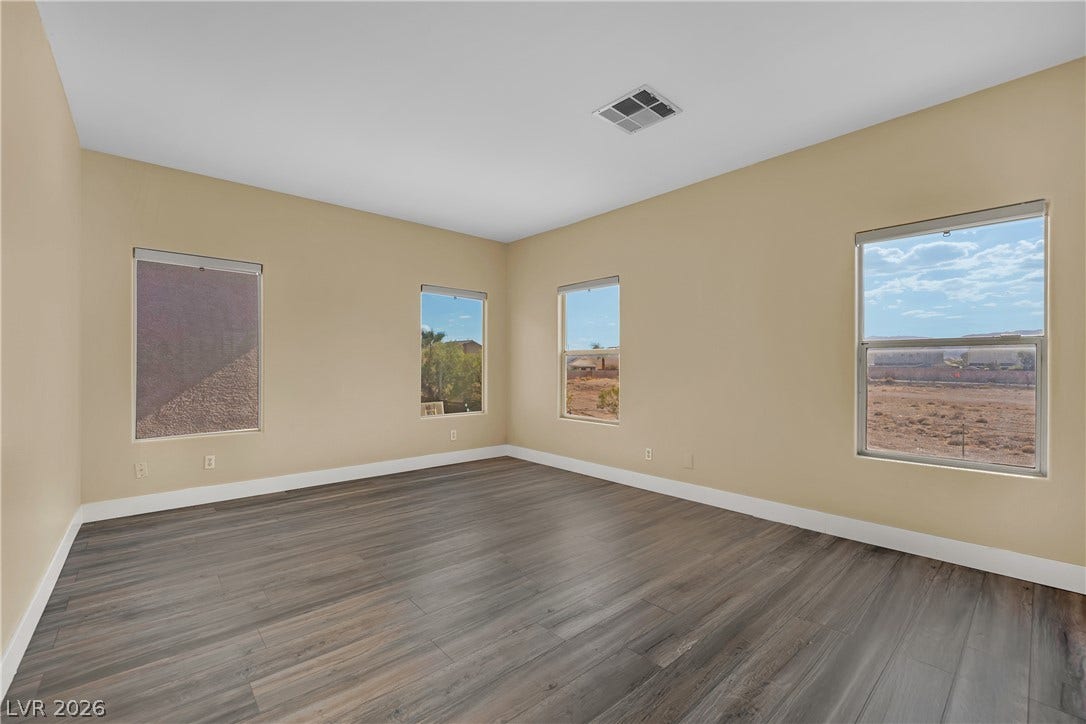 5823 Golden Wing Street, Las Vegas, NV 89113 Four windows illuminate this spacious bedroom, featuring durable wood flooring.