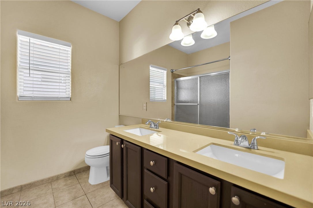 5823 Golden Wing Street, Las Vegas, NV 89113 Dual vanities and a large mirror illuminate this functional and well-kept bathroom.