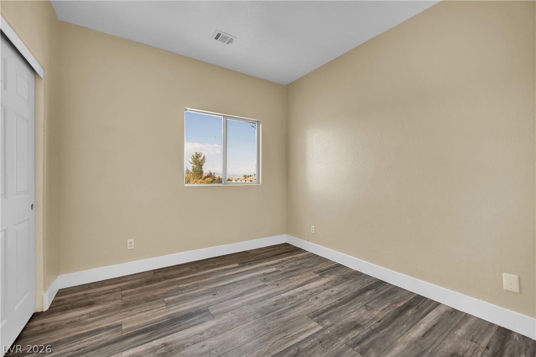 5823 Golden Wing Street, Las Vegas, NV 89113 A well-lit room features durable wood-look flooring and a single window offering distant views.