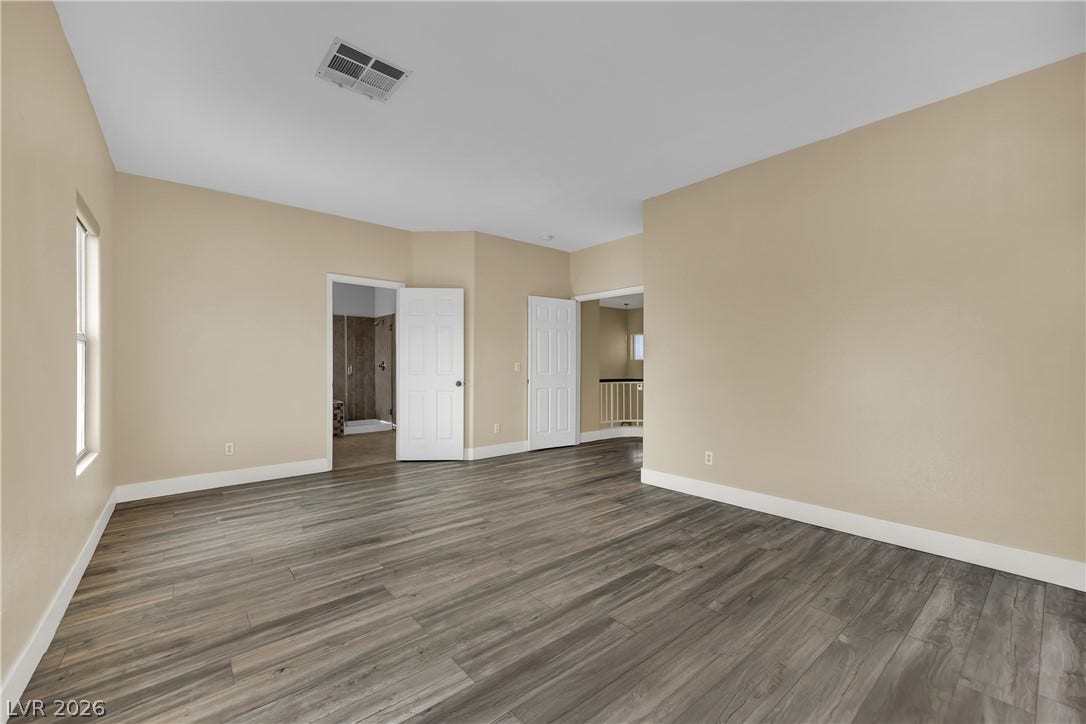 5823 Golden Wing Street, Las Vegas, NV 89113 A spacious room offers durable wood-look flooring and ample natural light from its windows.