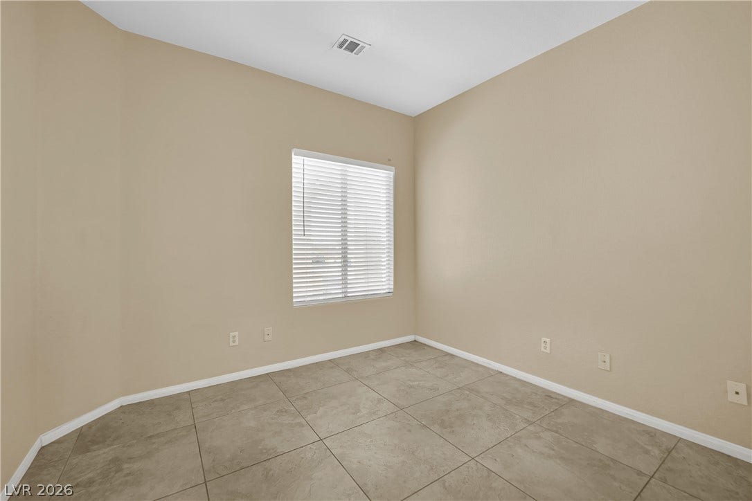 5823 Golden Wing Street, Las Vegas, NV 89113 A well-lit bedroom with neutral walls and durable tile flooring, offering a comfortable and adaptable living space.