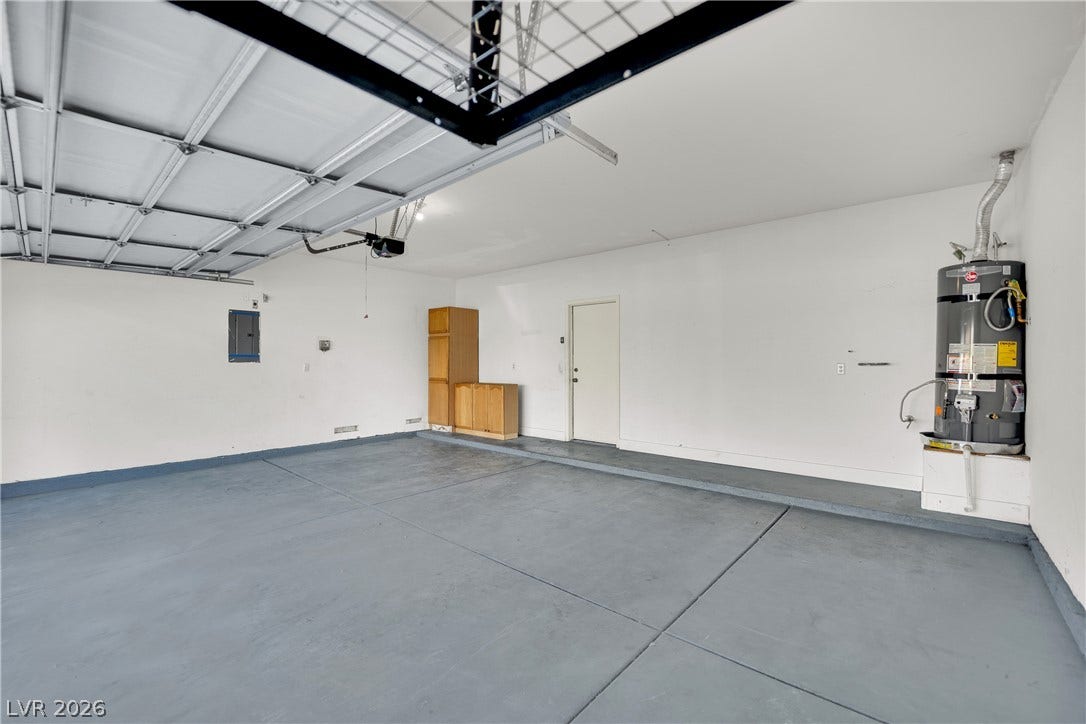 5823 Golden Wing Street, Las Vegas, NV 89113 A spacious garage with a freshly painted floor, offering ample storage and easy access.
