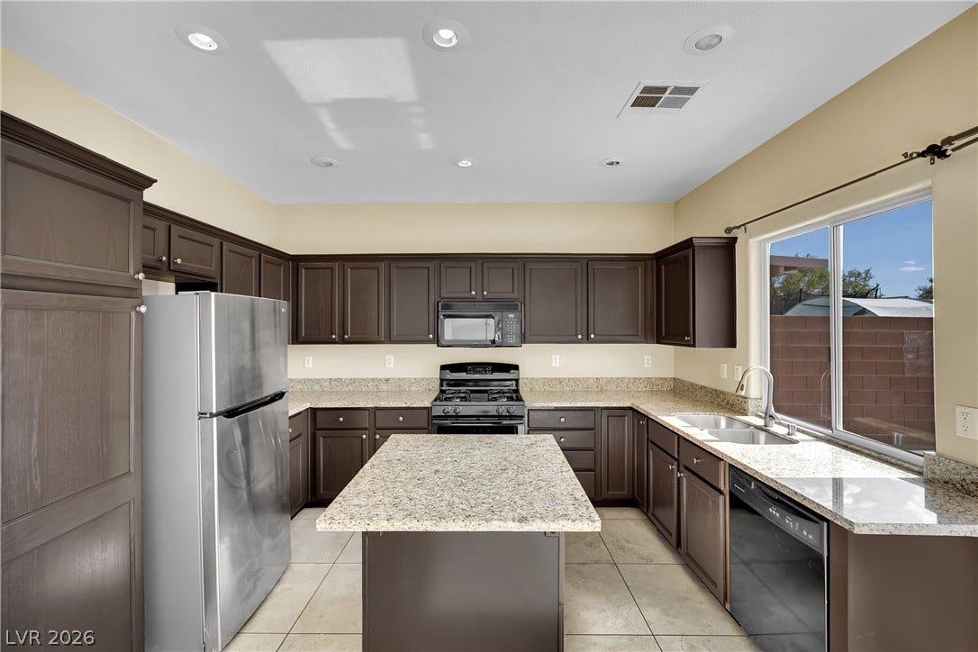 5823 Golden Wing Street, Las Vegas, NV 89113 A well-appointed kitchen features rich cabinetry, granite countertops, and modern appliances, complemented by abundant natural light.