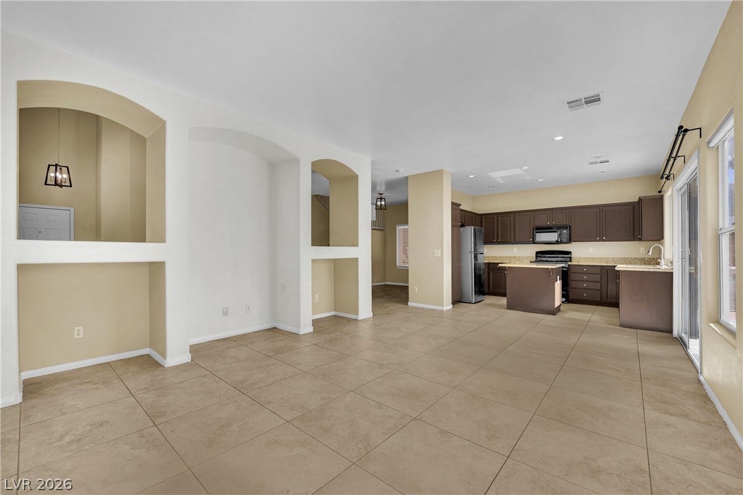 5823 Golden Wing Street, Las Vegas, NV 89113 An open-concept living space integrates a well-appointed kitchen with warm-toned cabinetry and practical tile flooring.