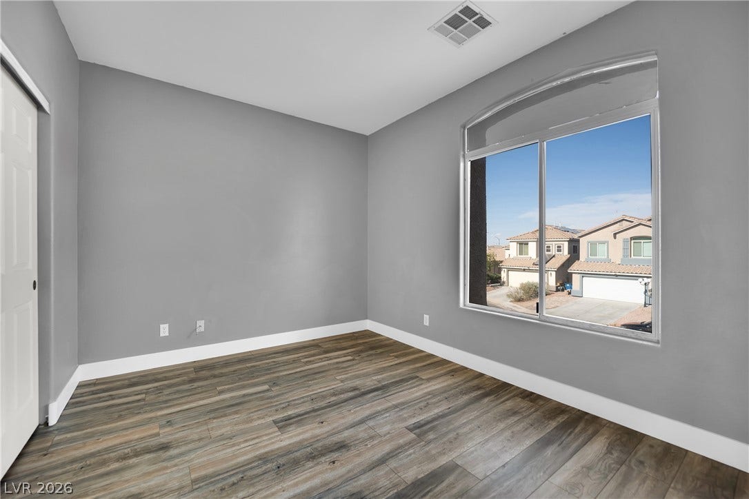 5823 Golden Wing Street, Las Vegas, NV 89113 A well-proportioned room with robust wood flooring, offering a street view through a broad window.