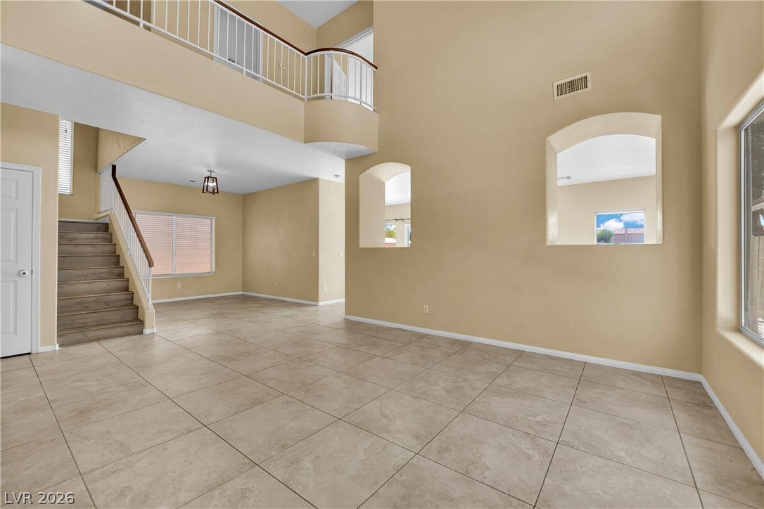 5823 Golden Wing Street, Las Vegas, NV 89113 A spacious entry leads to an inviting living area with a dramatic two-story ceiling and graceful arched openings.