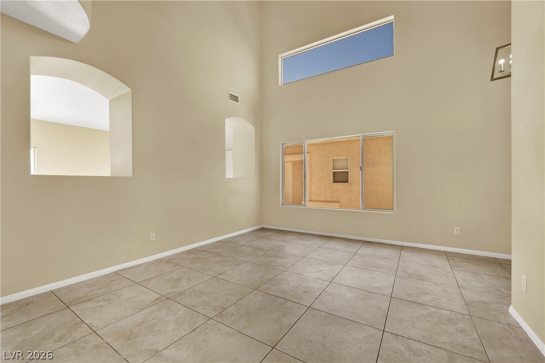 5823 Golden Wing Street, Las Vegas, NV 89113 Natural illumination streams into this room through a high horizontal window and a large sliding window, highlighting the tiled flooring.