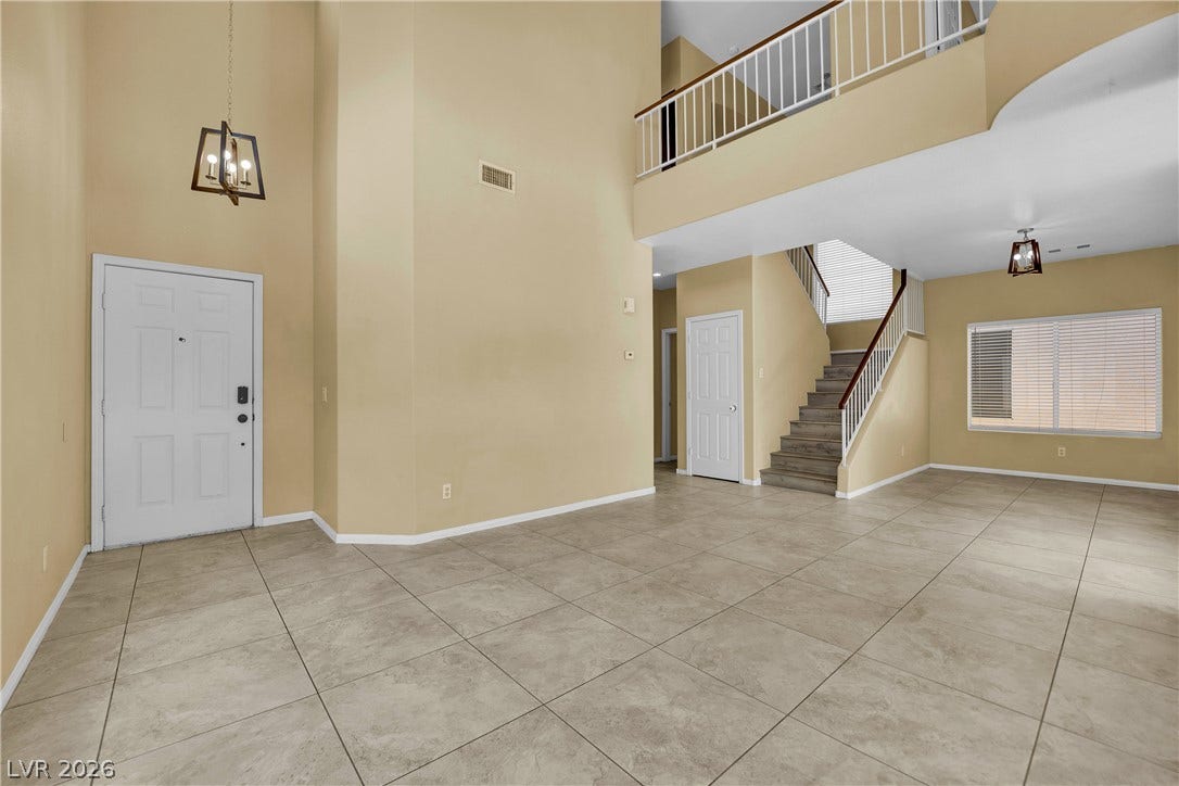 5823 Golden Wing Street, Las Vegas, NV 89113 Enter into this home with its two-story foyer and an inviting staircase, highlighting the generous floor space.